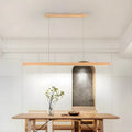 Linear wooden LED bar pendant light over a dining table by BROKLEN – view 11